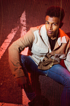 Man posing in the street at night.