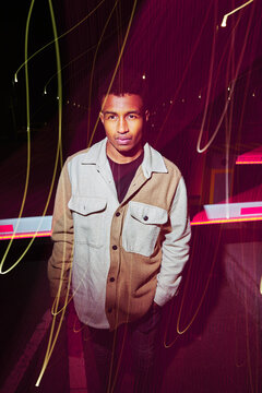 Man posing outdoors at night.