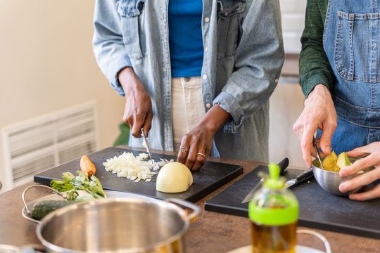 Anonymous Detail Of The Hands Of People Cooking In The Kitchen.