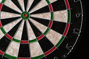 New classic professional sisal dart board on black wooden background. Close up.