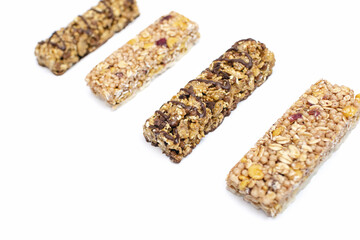 A set of different muesli bars on a white isolated background. A tasty and healthy snack in the form of whole grain oatmeal nut and chocolate bars with berries. Sweet and healthy snack