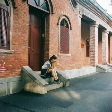 Female students making faces sitting on the library steps