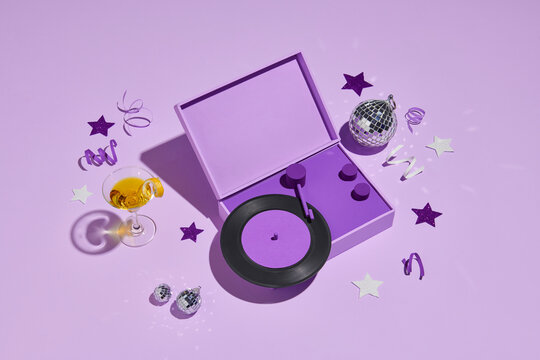 A martini glass with orange cocktail on purple background