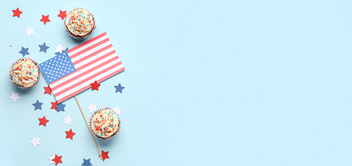Obraz premium Tasty patriotic cupcakes and flag of USA on light blue background with space for text. American Independence Day
