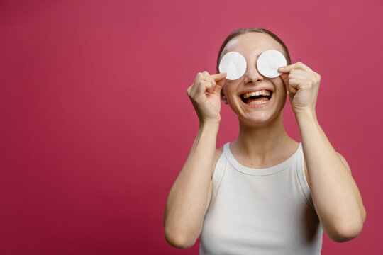 A woman covers her eyes with cotton pads