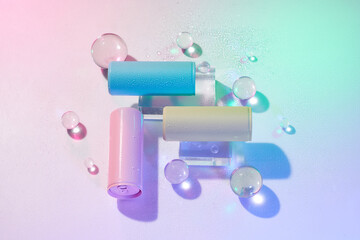 Three cans of cold beverage on crystal blocks over colorful background
