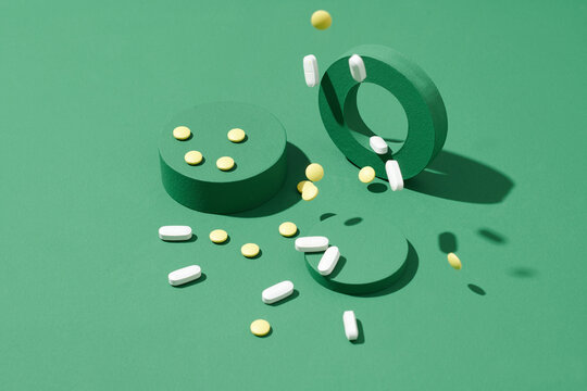 Medicinal scattered tablets with green ring blocks on color background