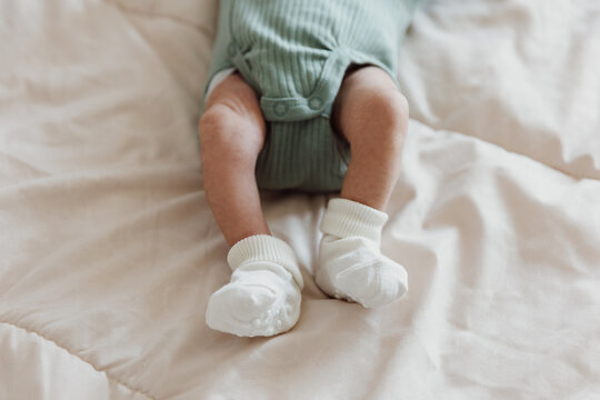 Crop newborn lying on bed