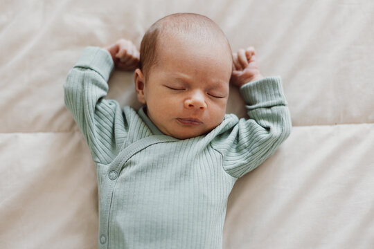 Cute newborn baby sleeping on bed at home
