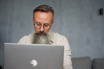 Senior Man Working With The Laptop At Office