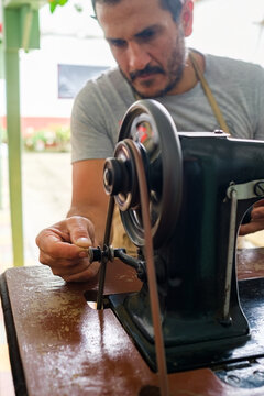 Close-up of a tailor arranging thread on a sewing machine