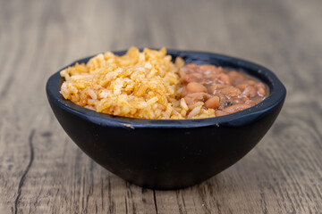 Half and half bowl of whole pinto beans and Mexican rice for a meal side order