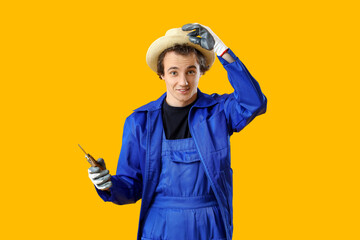 Male gardener with secateurs on yellow background