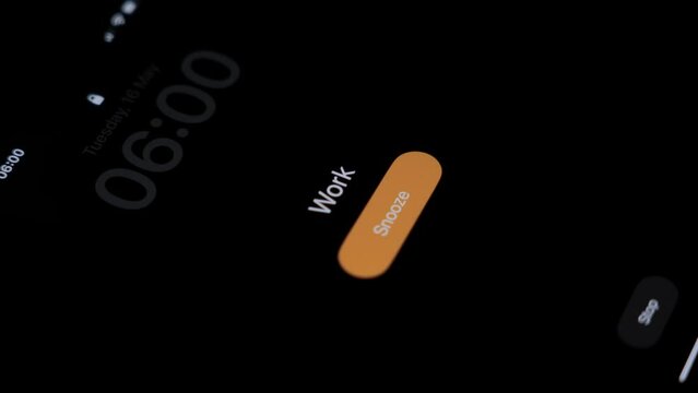 In the dark room of the bedroom, the alarm clock on the phone goes off at 6 o'clock in the morning with the inscription Work. The inscription work on the alarm clock. High quality 4k footage