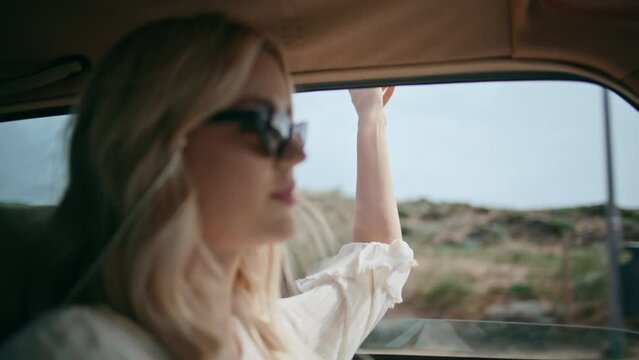 Carefree girl riding automobile putting hand in open window closeup. Driving car