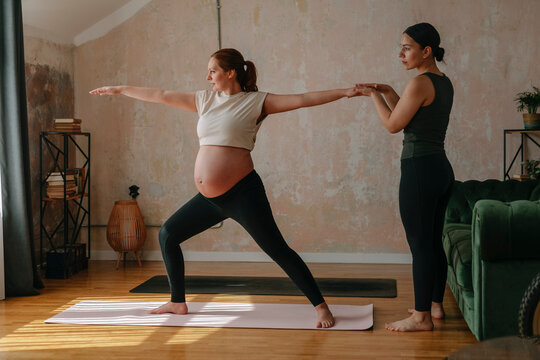 Pregnant Woman Doing Yoga With Instructor