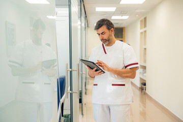 Portrait of doctor using digital tablet in the consultation.