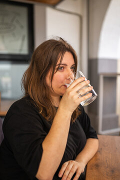 Young Woman Sitting In A Cafeteria Having A Soft Drink