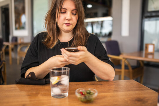 Young Woman Using Mobile Phone In A City Cafe