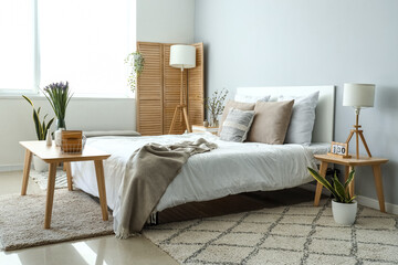 Interior of light living room with blooming iris flowers on table