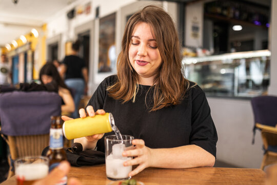 young woman sitting in a cafeteria having a soft drink