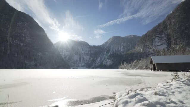 Pan of frozen lake in Bavarian alps on sunny day in koenigssee national park