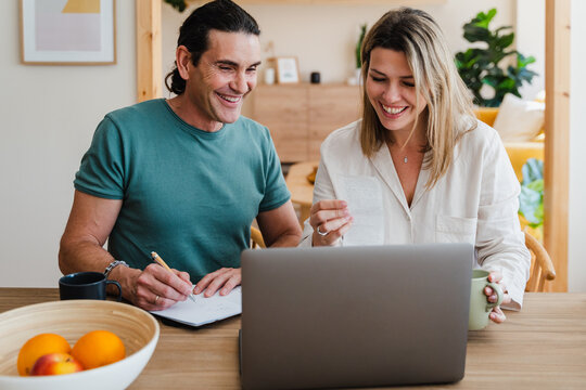 Cheerful Couple Paying Bill At Home