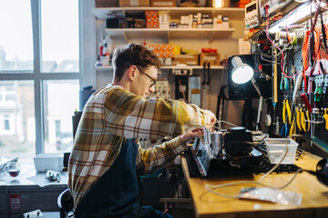 Handy man repairing amplifier in garage