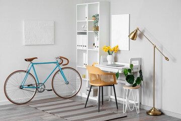 Interior of modern office with comfortable workplace and bicycle