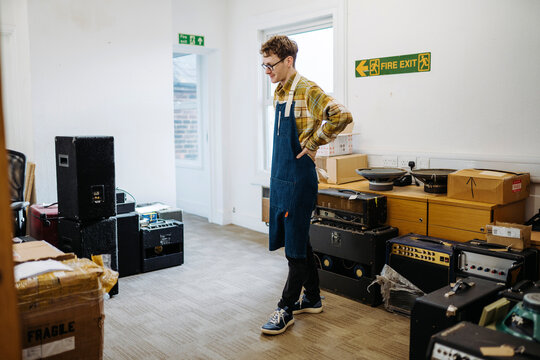 Repairman with guitar amplifiers at workplace