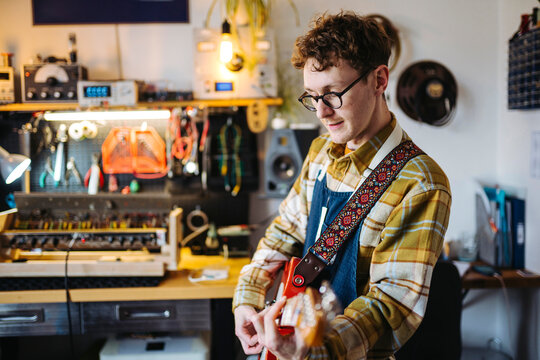Male musician with guitar in workshop