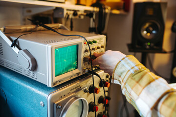 Anonymous master adjusting oscillograph in repair shop