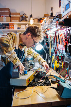 Busy male in guitar amplifier workshop