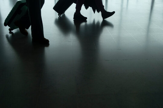 two people walking with suitcases legs closeup