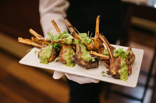 Server Presents Lamb Chops Appetizer