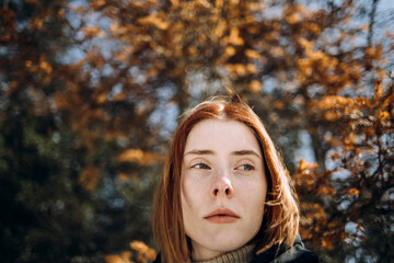 Portrait of a red-haired girl In autumn park