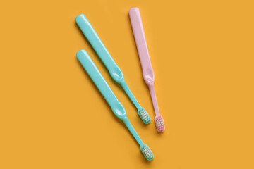 Plastic toothbrushes on yellow background