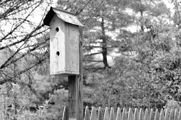 Birdhouse setting on a farmers fence post In Lake Winola Pennsylvania on a May day.