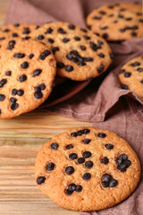Tasty cookies with chocolate chips on wooden background