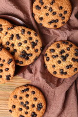 Tasty cookies with chocolate chips on wooden background