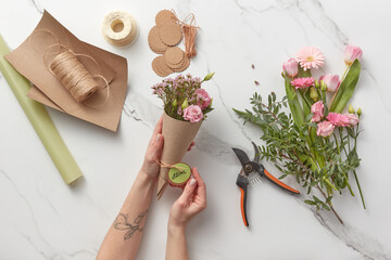 Woman holds bouquet with Mother's Day card.