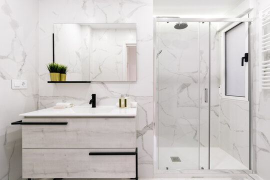 Modern marble-like bathroom interior with shower cabinet