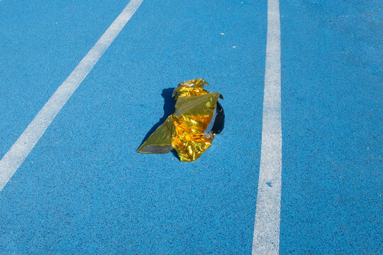 Golden metallic folio on a  blue sport running track