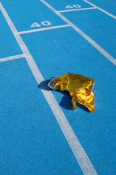 Golden metallic folio on a  blue sport running track