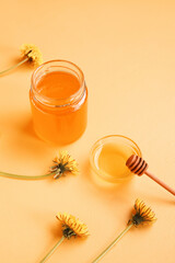 Obraz na płótnie Canvas Jar and bowl with dandelion honey on orange background
