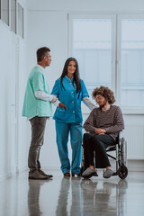 Doctor and a nurse discussing a patient's health while the patient, who is in a wheelchair, is...