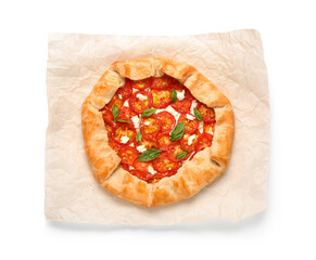 Baking paper with tasty tomato galette and basil on white background