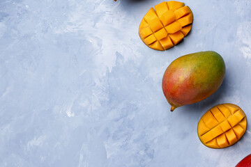 Fresh ripe mangoes on light blue background