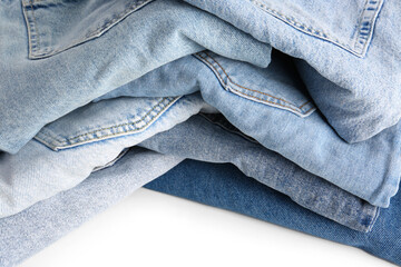 Different folded denim jeans on white background