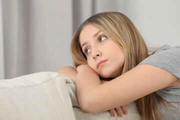 Naklejka premium Upset teenage girl on sofa at home